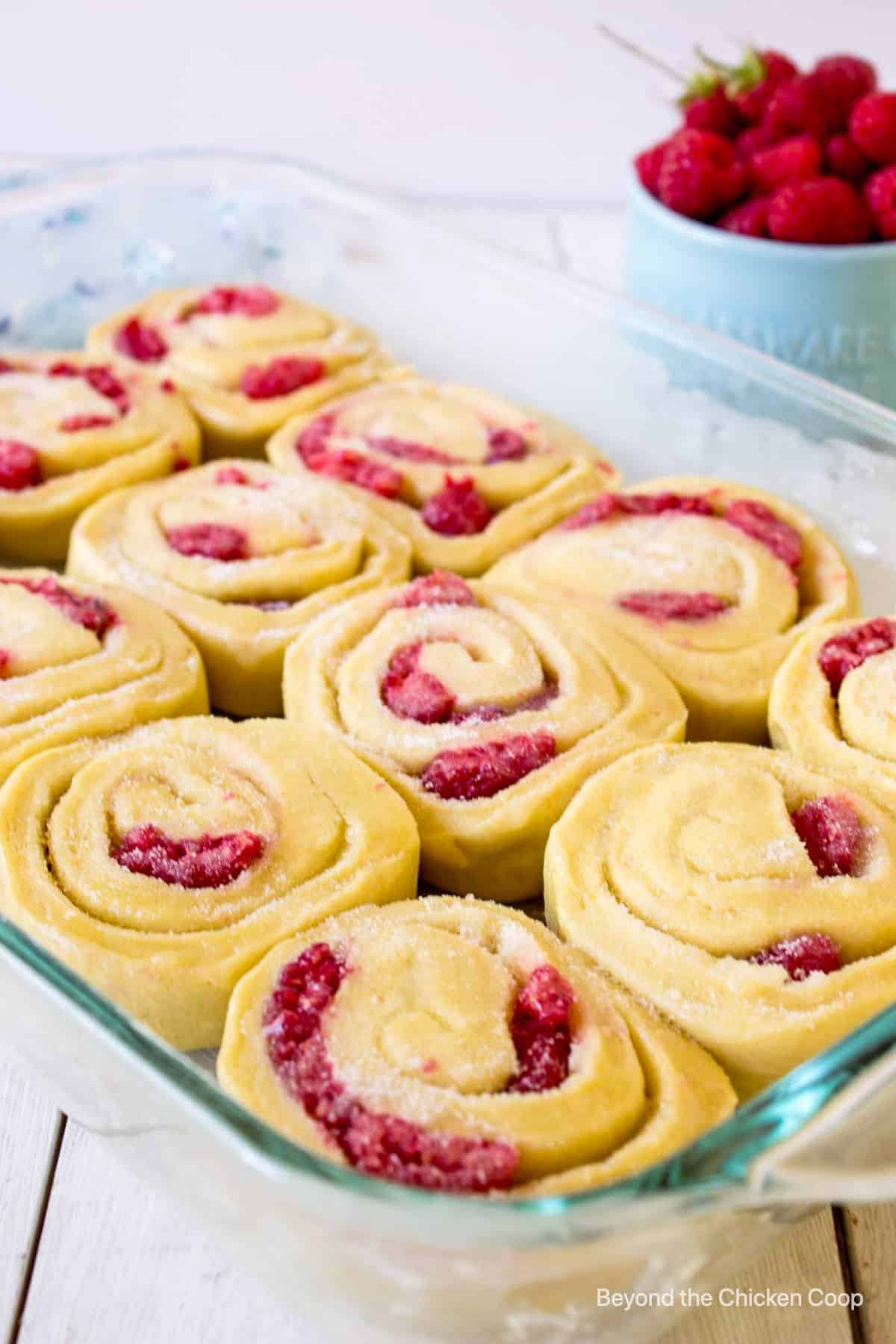 A baking dish filled with unbaked sweet rolls.