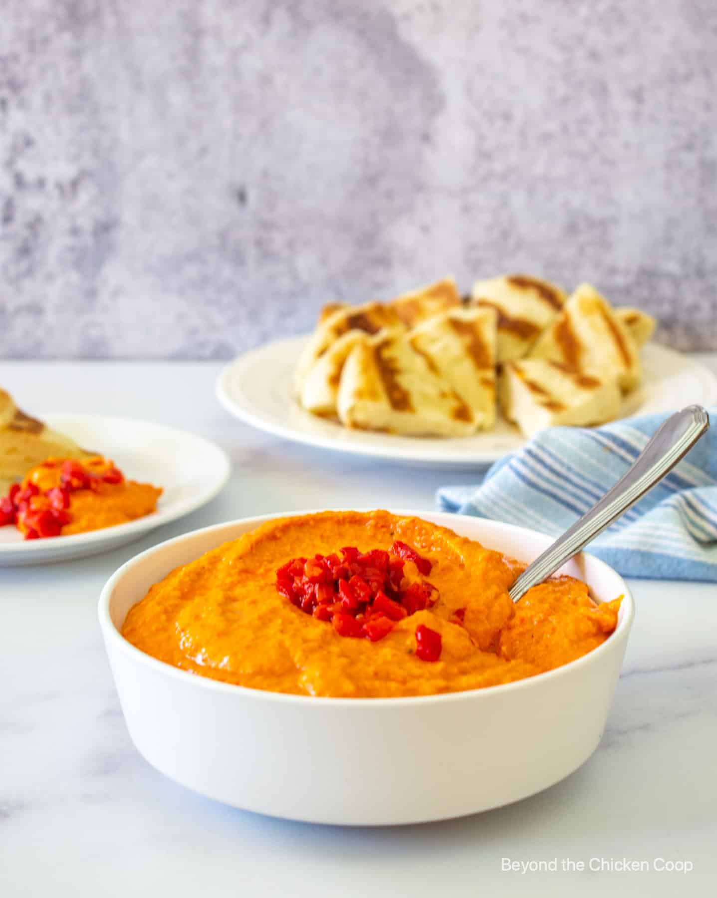 Hummus in a bowl with a spoon.