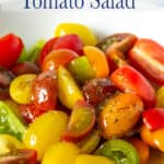 Quartered cherry tomatoes in a white bowl.