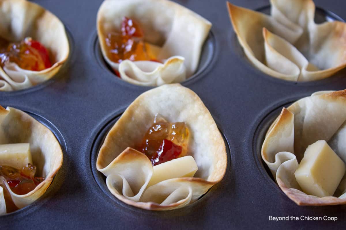 Pepper jelly with cheese in a wonton cup.