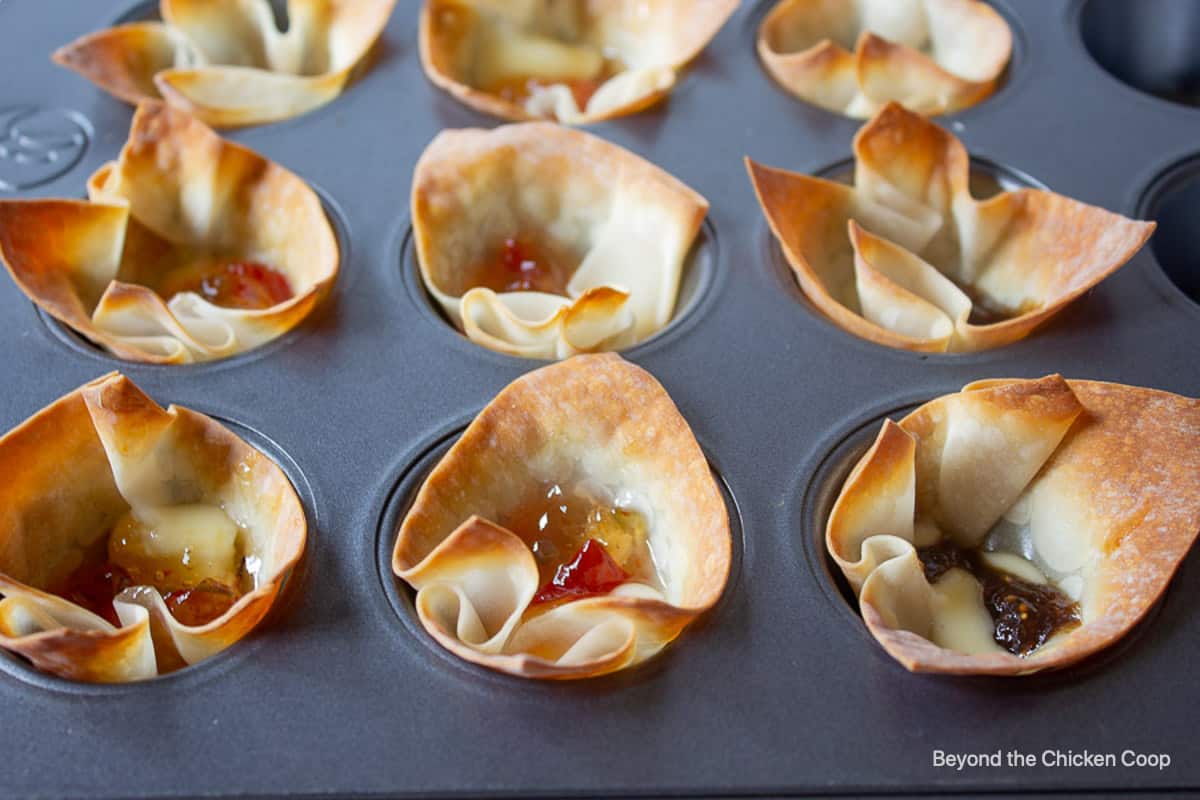 Wonton cups filled with baked cheese and jelly.