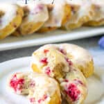 Donuts with raspberries on a white plate.