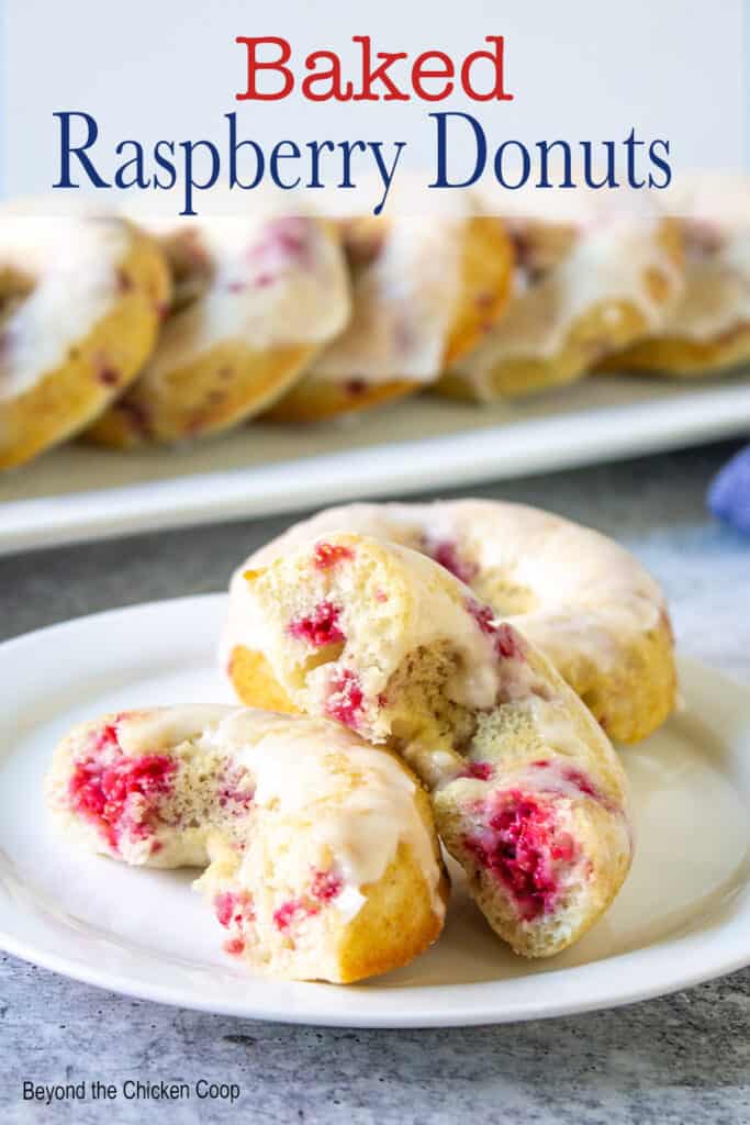 Donuts with raspberries on a white plate.