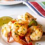 Cooked shrimp on a plate with a lime wedge.