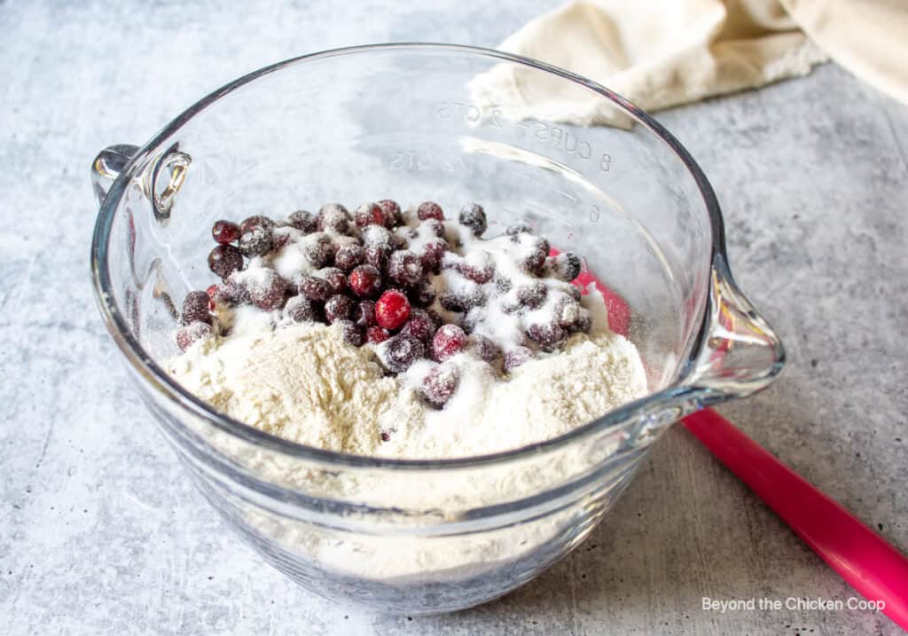 Huckleberries in a bowl with flour and sugar.