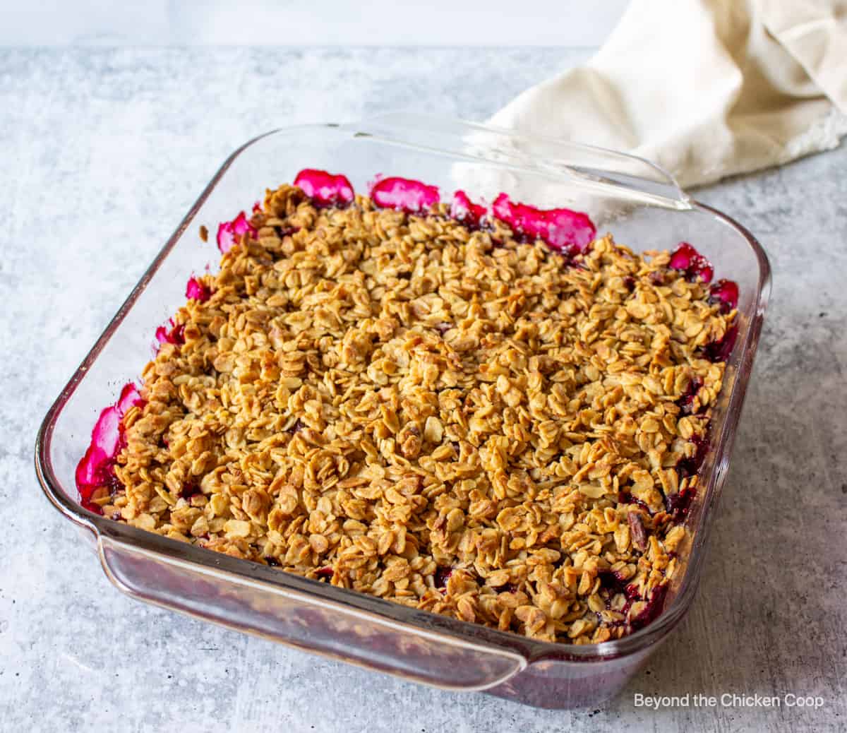 A baked crisp with granola and red berries. 