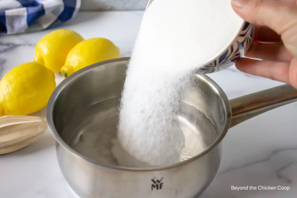 Sugar being poured into a saucepan.