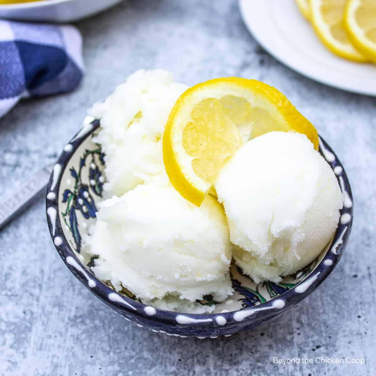 A blue bowl with scoops of lemon sorbet.