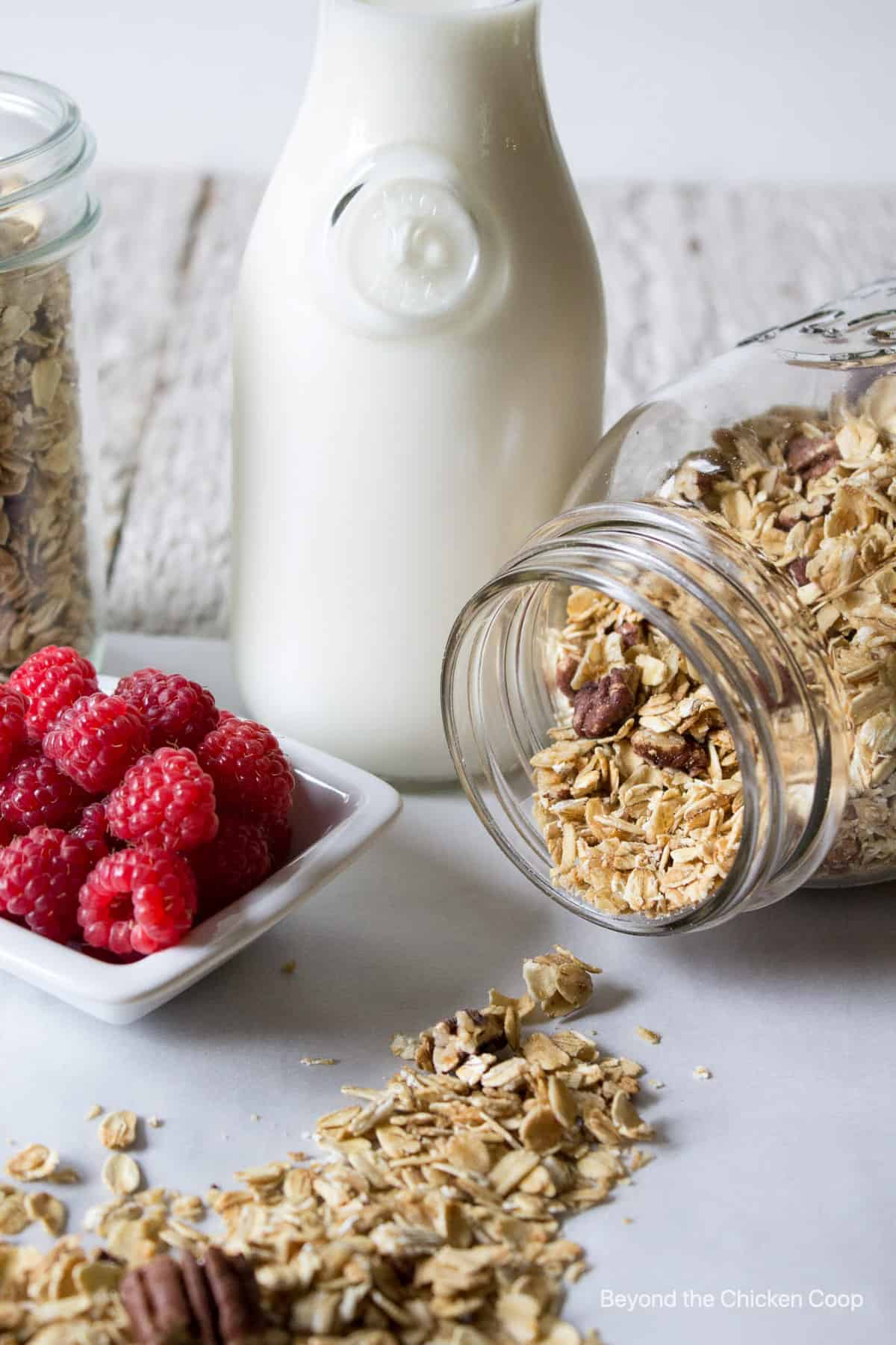 Granola spilling out of a glass jar onto the counter.