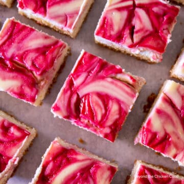Cheesecake squares topped with a raspberry swirl.