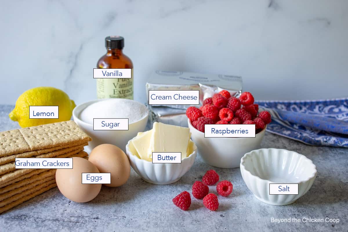 Ingredients for making cheesecake bars with raspberries.