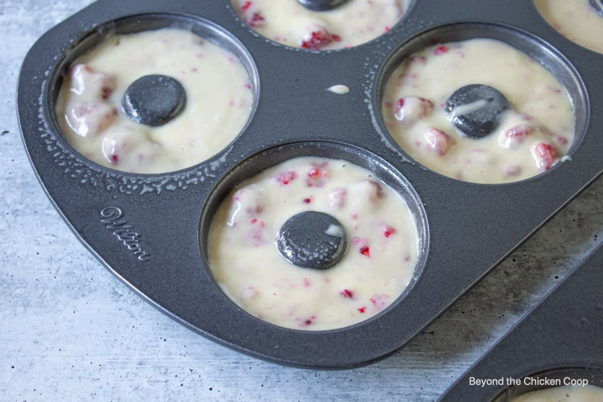 A donut pan with raspberry batter.