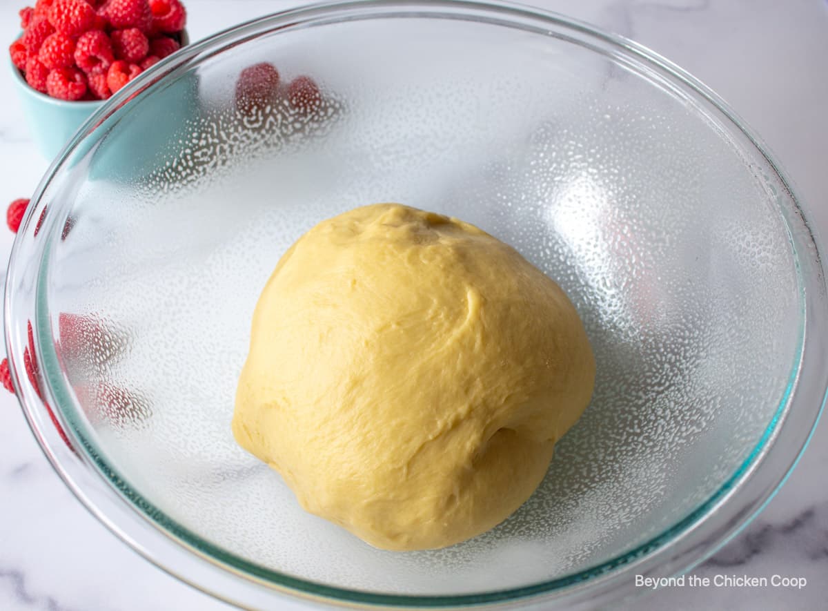 Bread dough in a glass bowl.