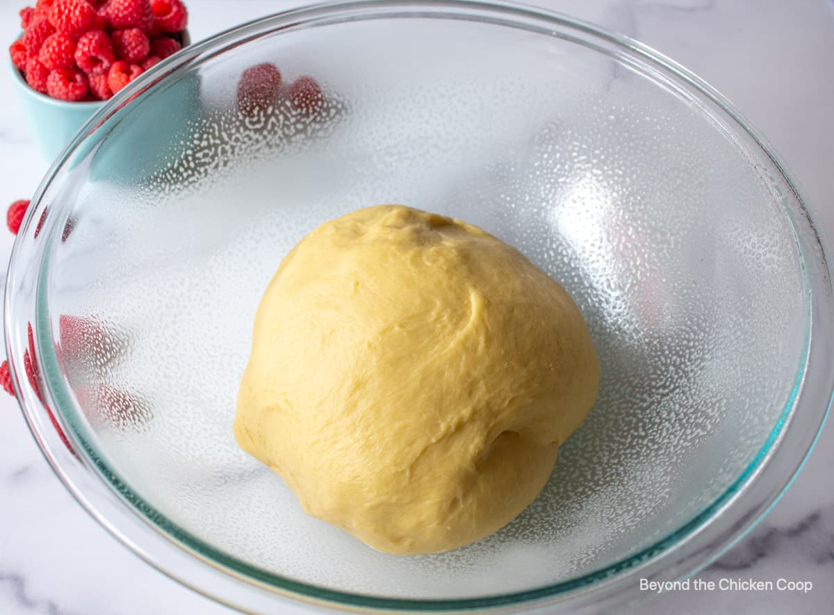 Bread dough in a glass bowl.