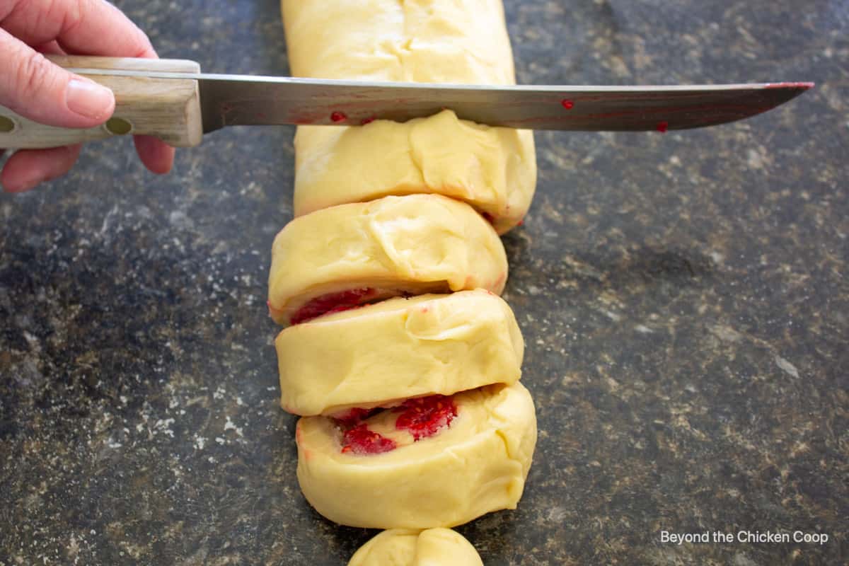 Slicing sweet roll dough.
