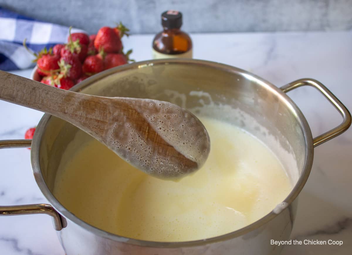 The back of a wooden spoon covered with a custard.