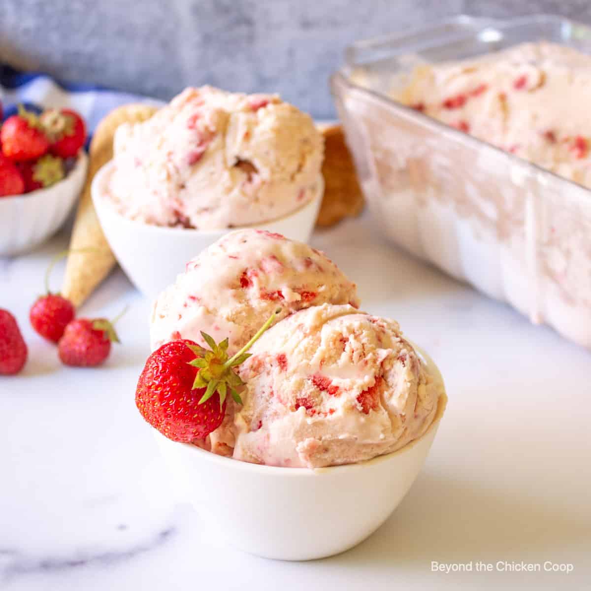 Scoops of strawberry ice cream in a bowl.