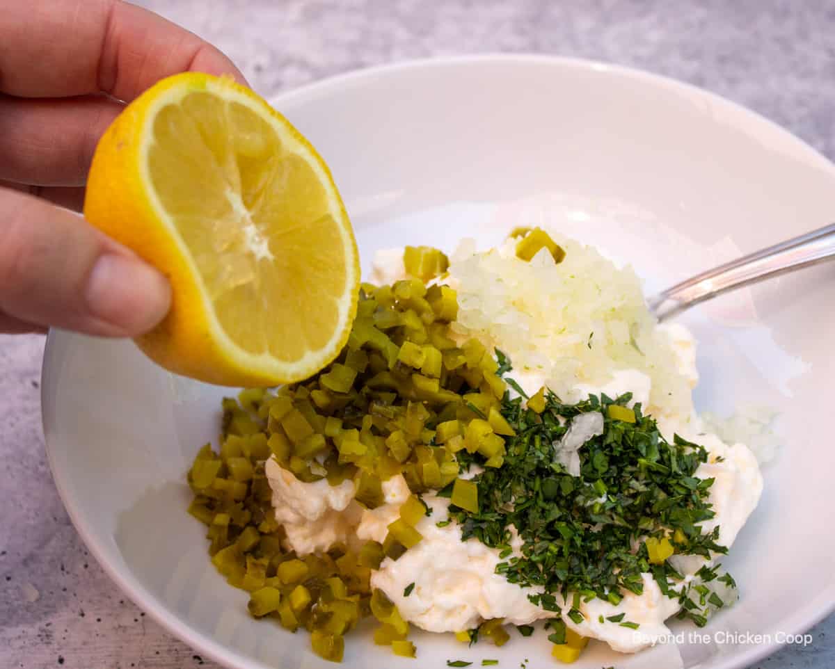 Squeezing a lemon into a bowl.