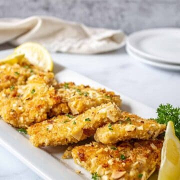 Baked fish with an almond crust on a platter.
