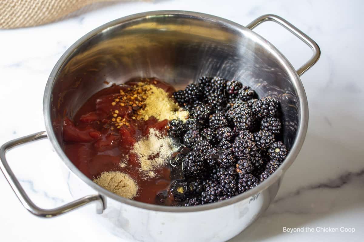 Blackberries and other ingredients in a saucepan.
