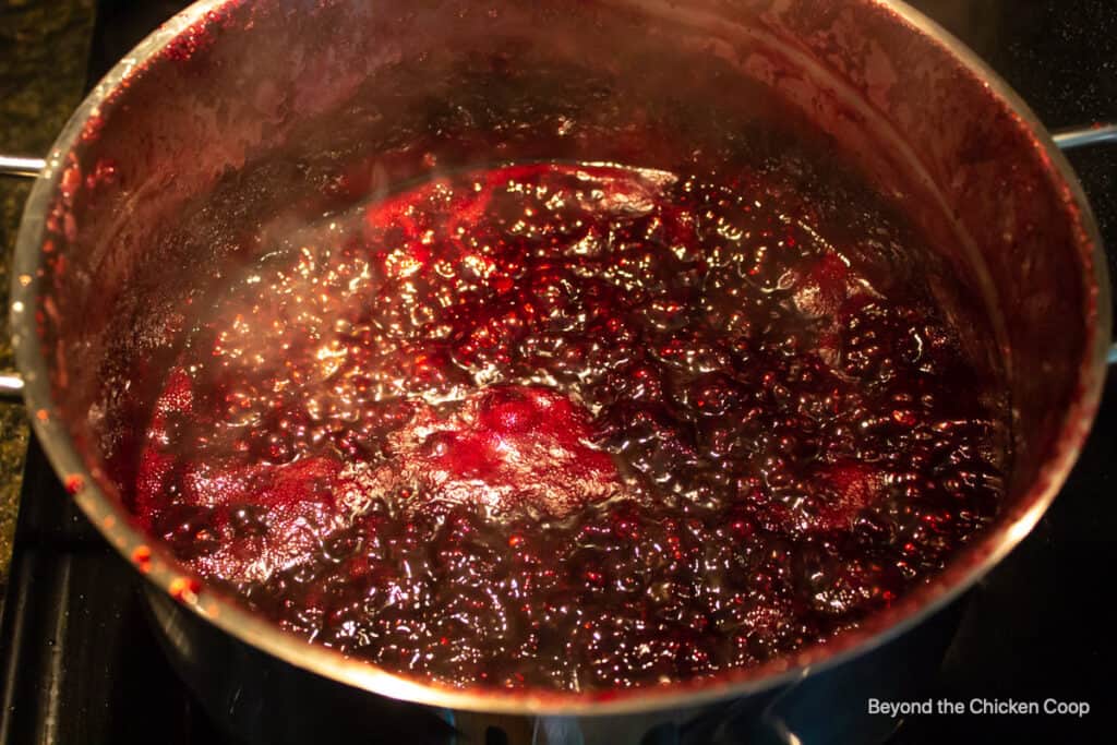 Blackberry jam boiling in a large pot.