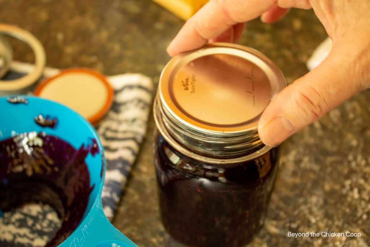 Placing a lid on a canning jar.