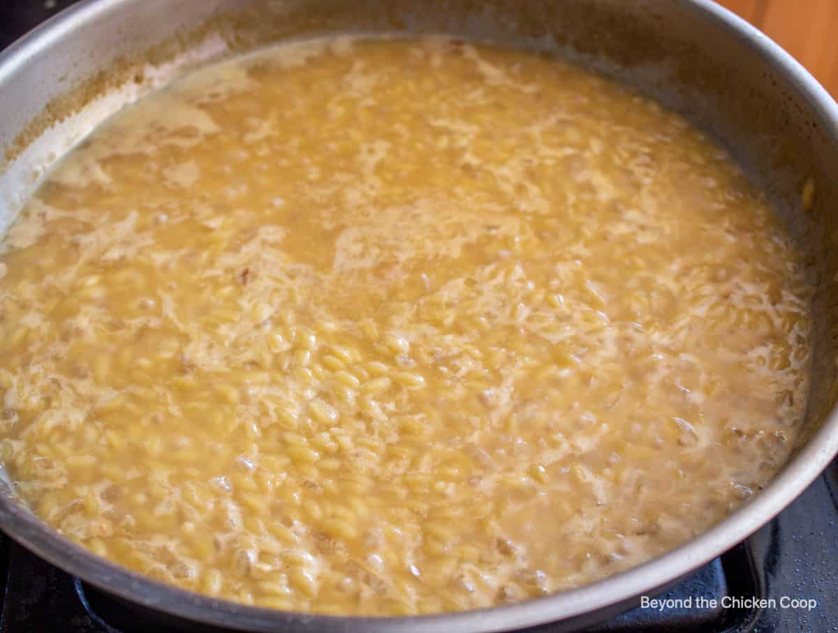 Pasta simmering in a large fry pan.