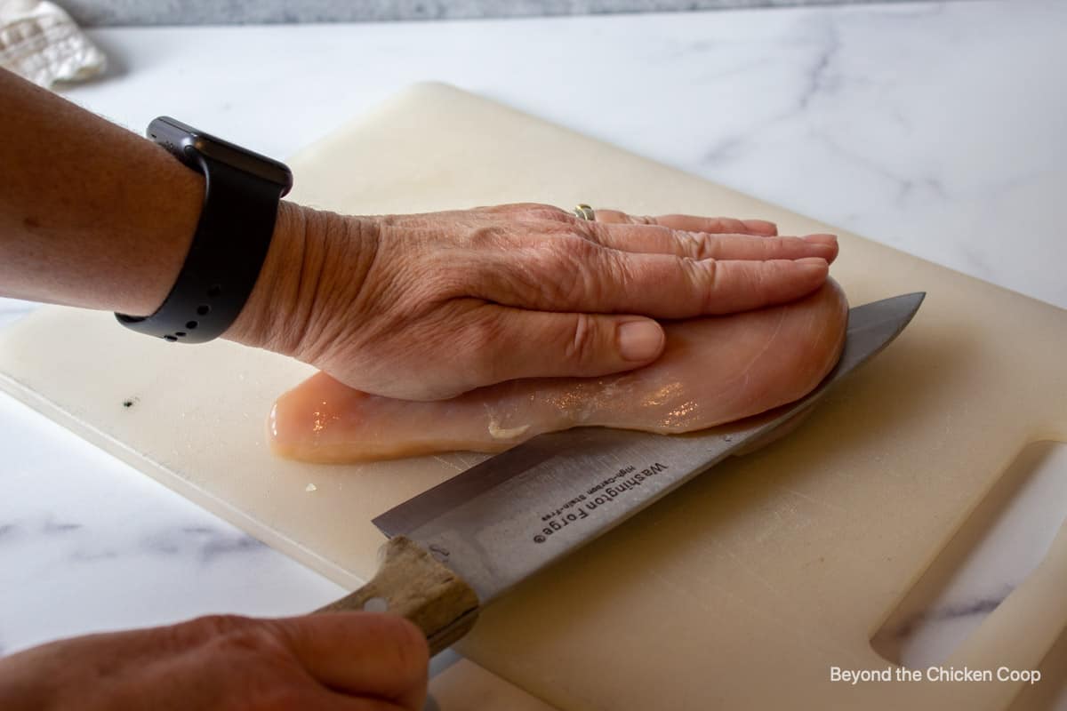 Cutting a chicken breast in half.