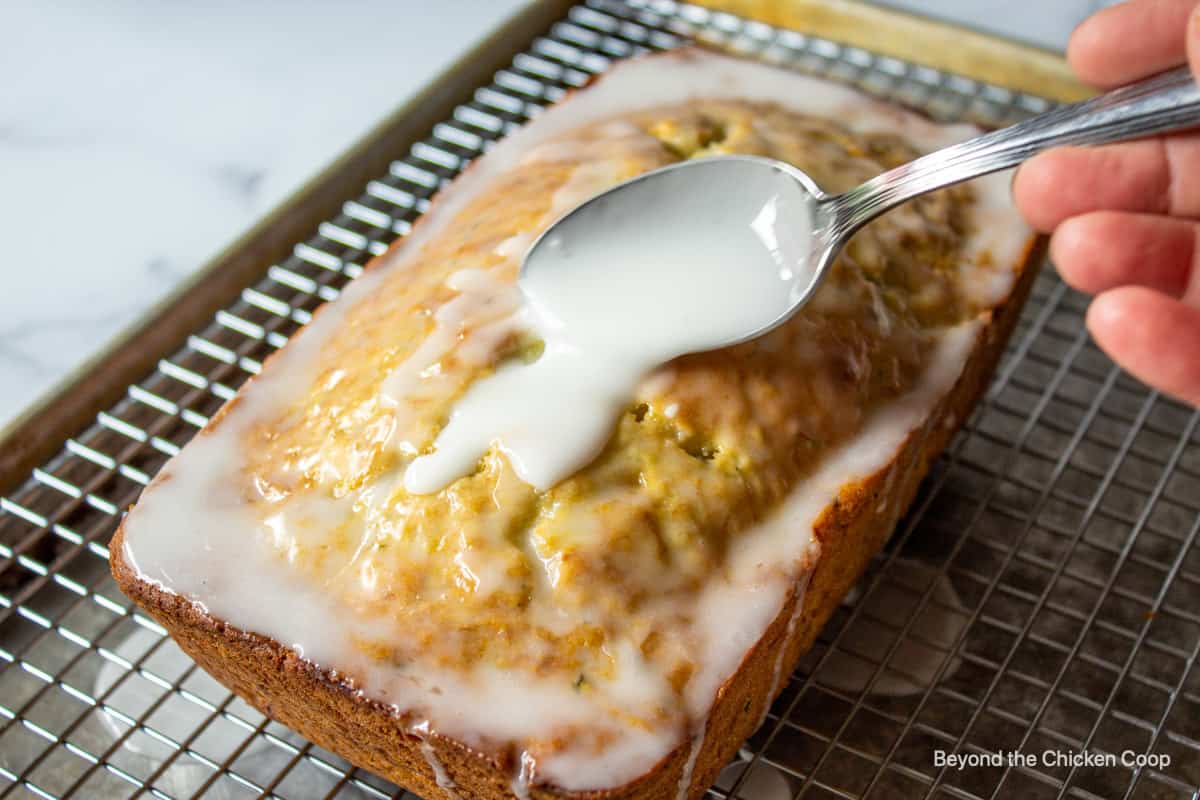 Spooning a glaze on top of a loaf of bread.