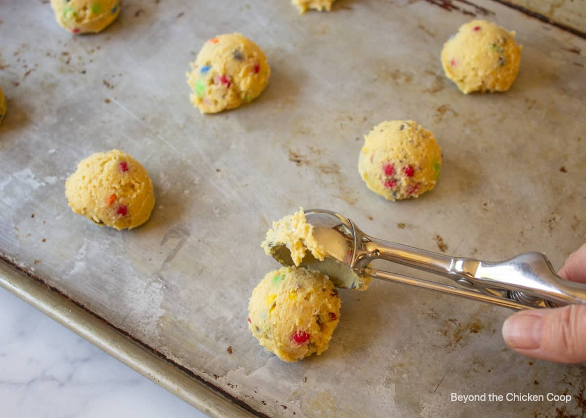 Scooping cookie dough onto a baking sheet.