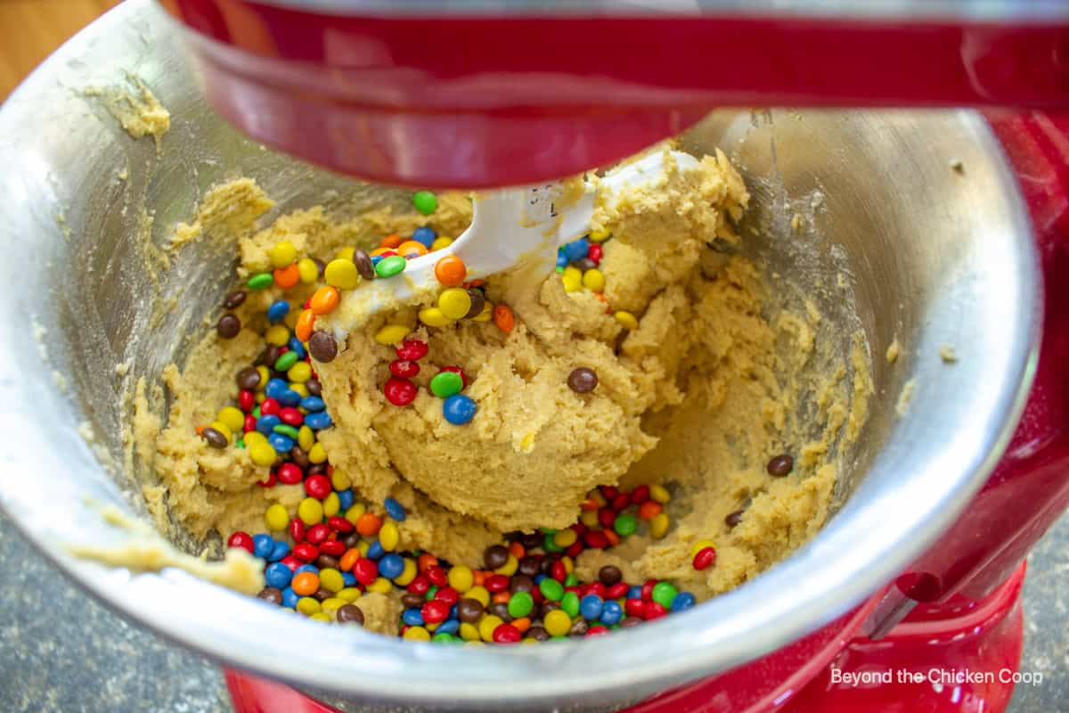 Candy pieces along with cookie dough in a bowl.