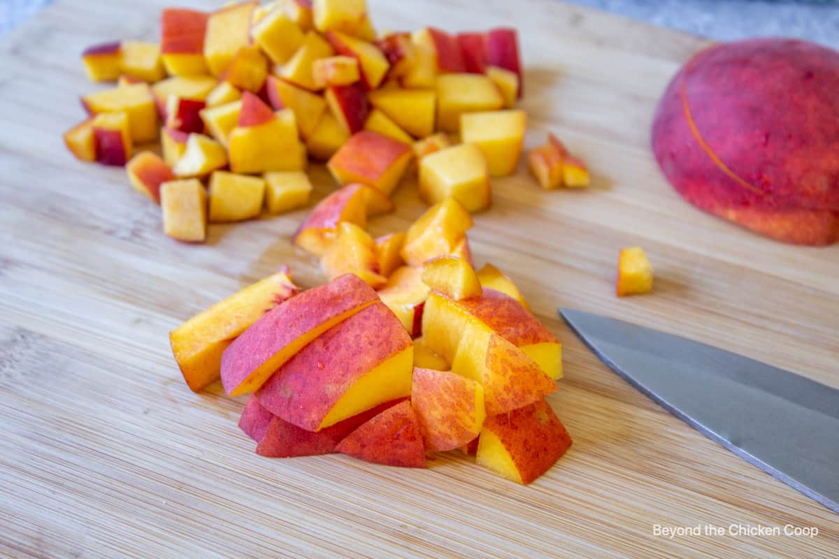 Diced peaches on a cutting board.