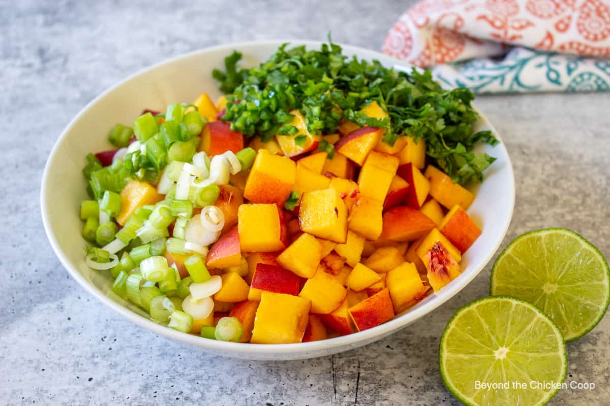 Chopped peaches and cilantro in a bowl.