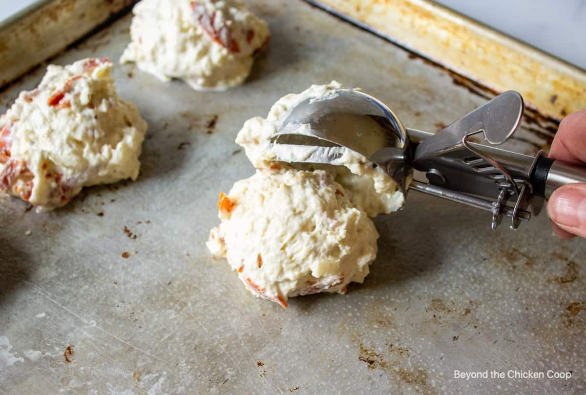 Scooping biscuit dough onto a baking sheet.