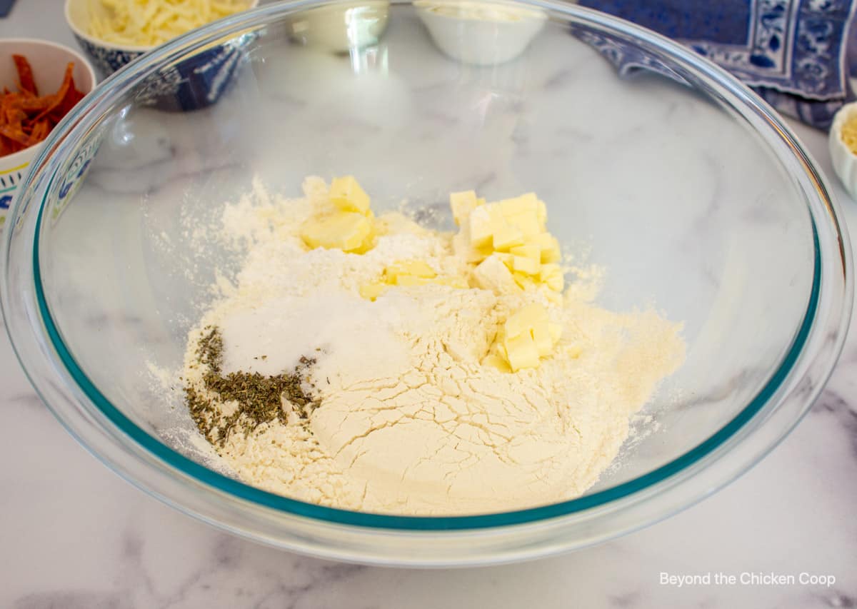 A glass bowl with flour, butter and seasonings.