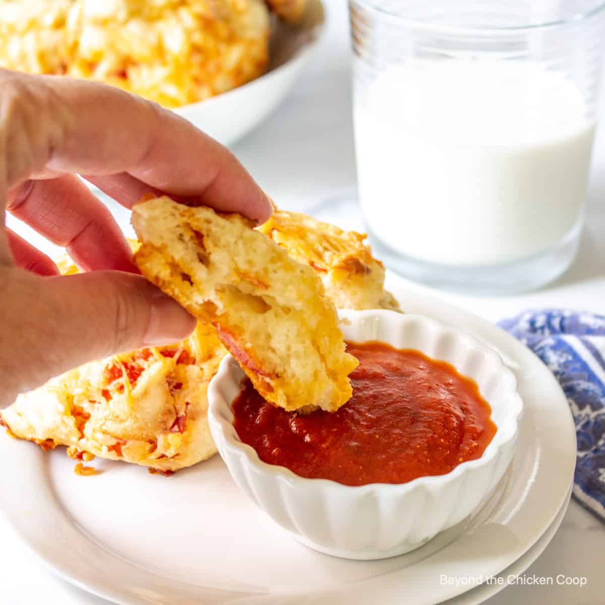 Pizza biscuits dipped into a tomato sauce.