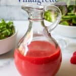 A berry salad dressing in a glass bottle.