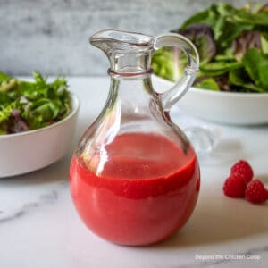 Raspberry vinaigrette in a glass cruet.