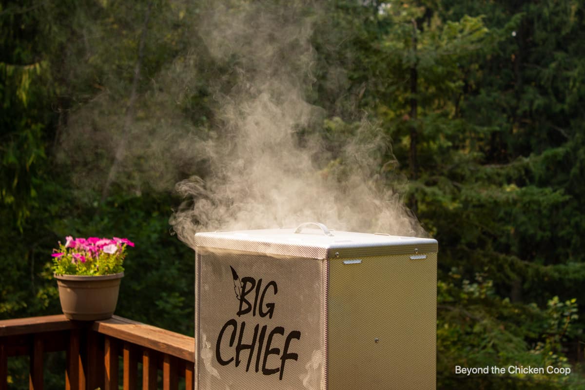 Smoke coming out of the top of a smoker.