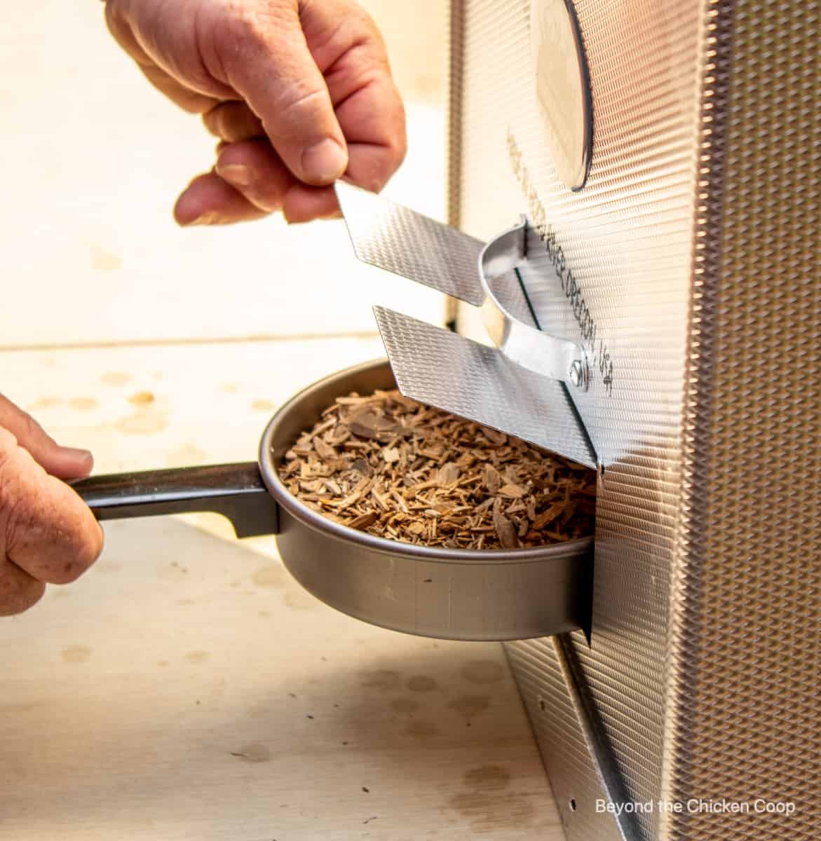 Wood chips added to a smoker.