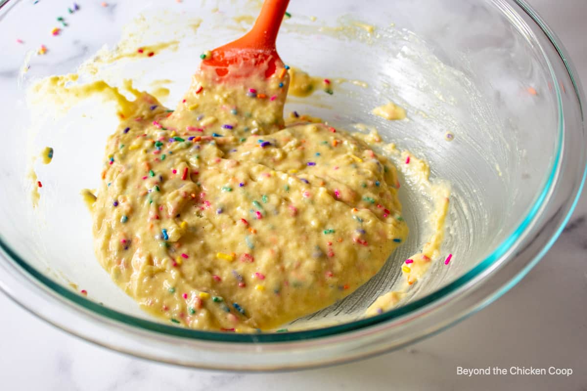 Funfetti donut batter in a glass bowl.