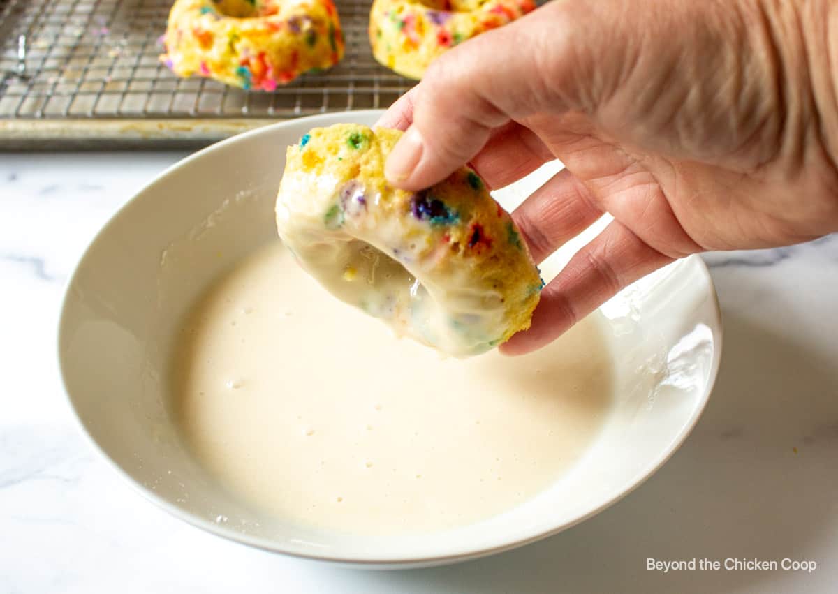 Dipping a donut into a glaze.