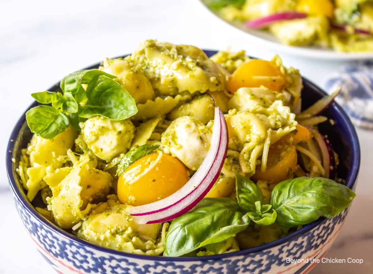 Pasta salad with tortellini and pesto in a large bowl.