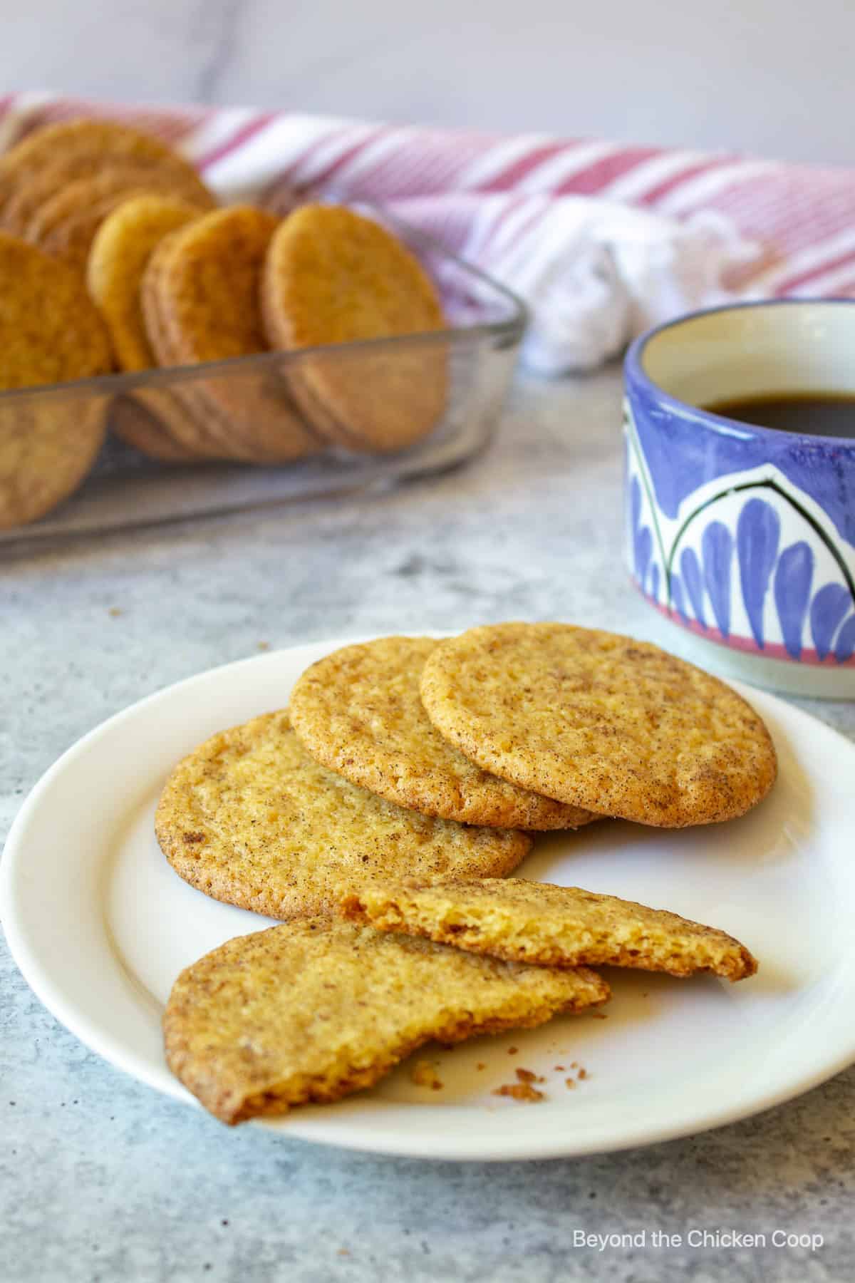 Cookies on a white plate with a cup of coffee in the background.