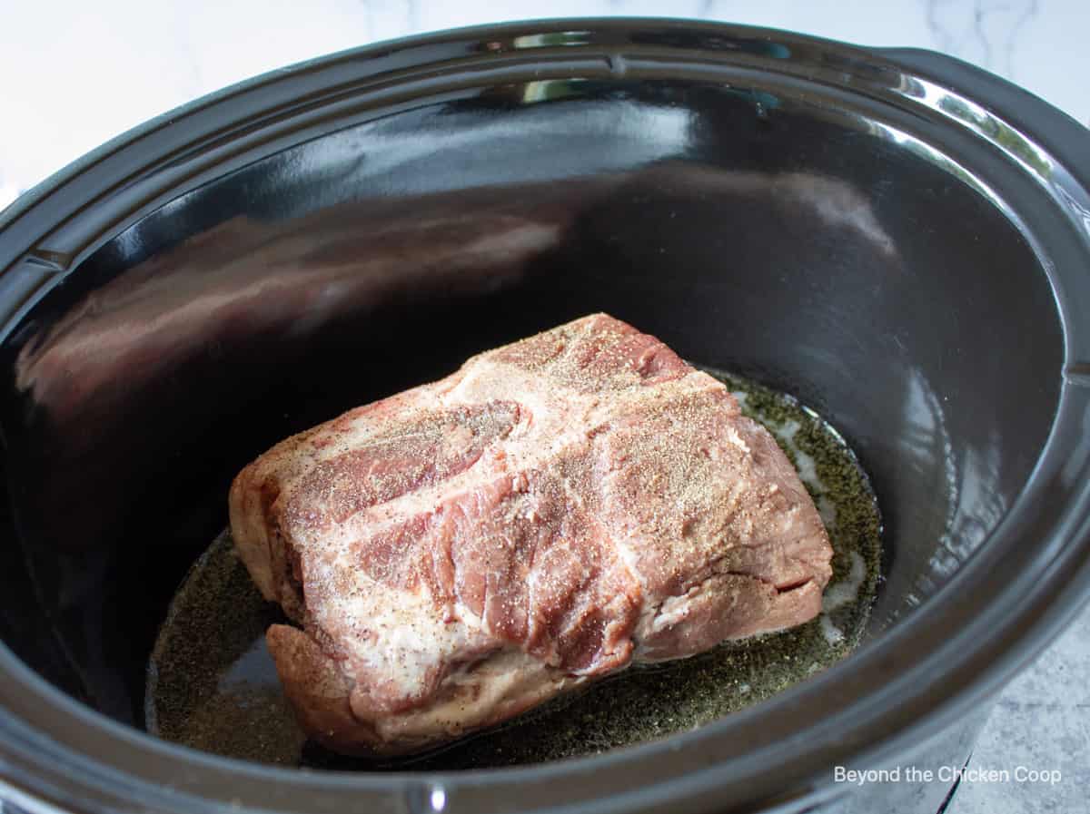 A pork roast in a slow cooker.