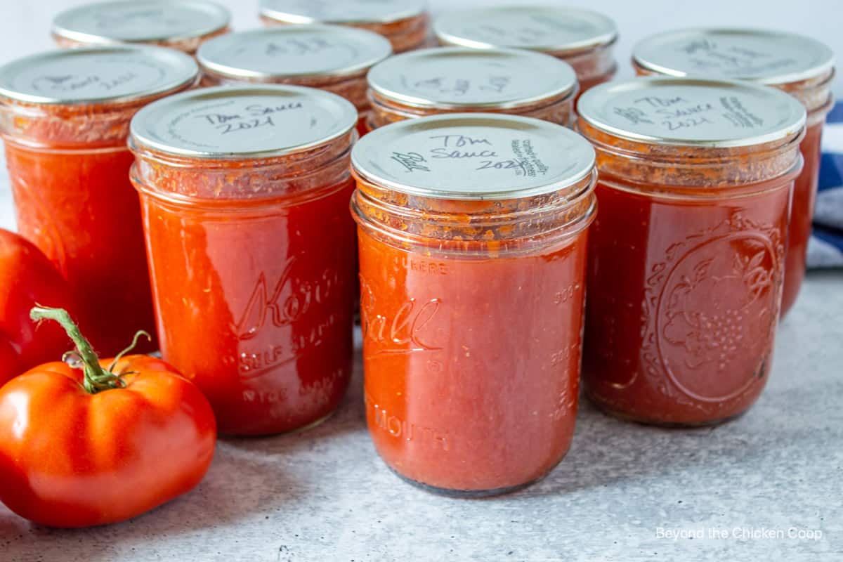 Home canning jars filled with a red sauce.