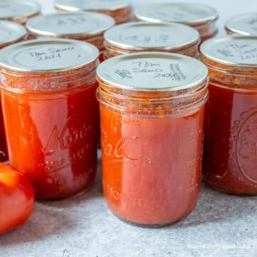 Canning jars filled with tomato sauce.