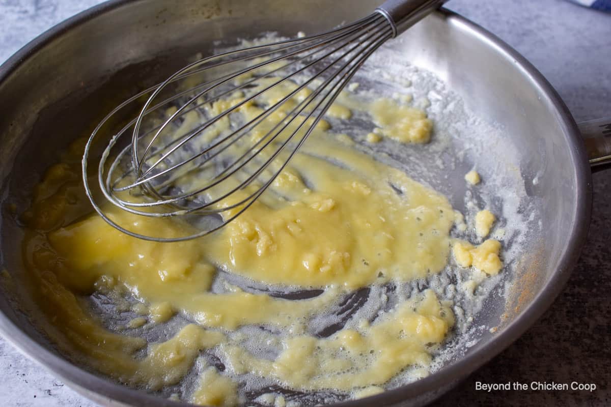 Flour and butter in a pan with a whisk.