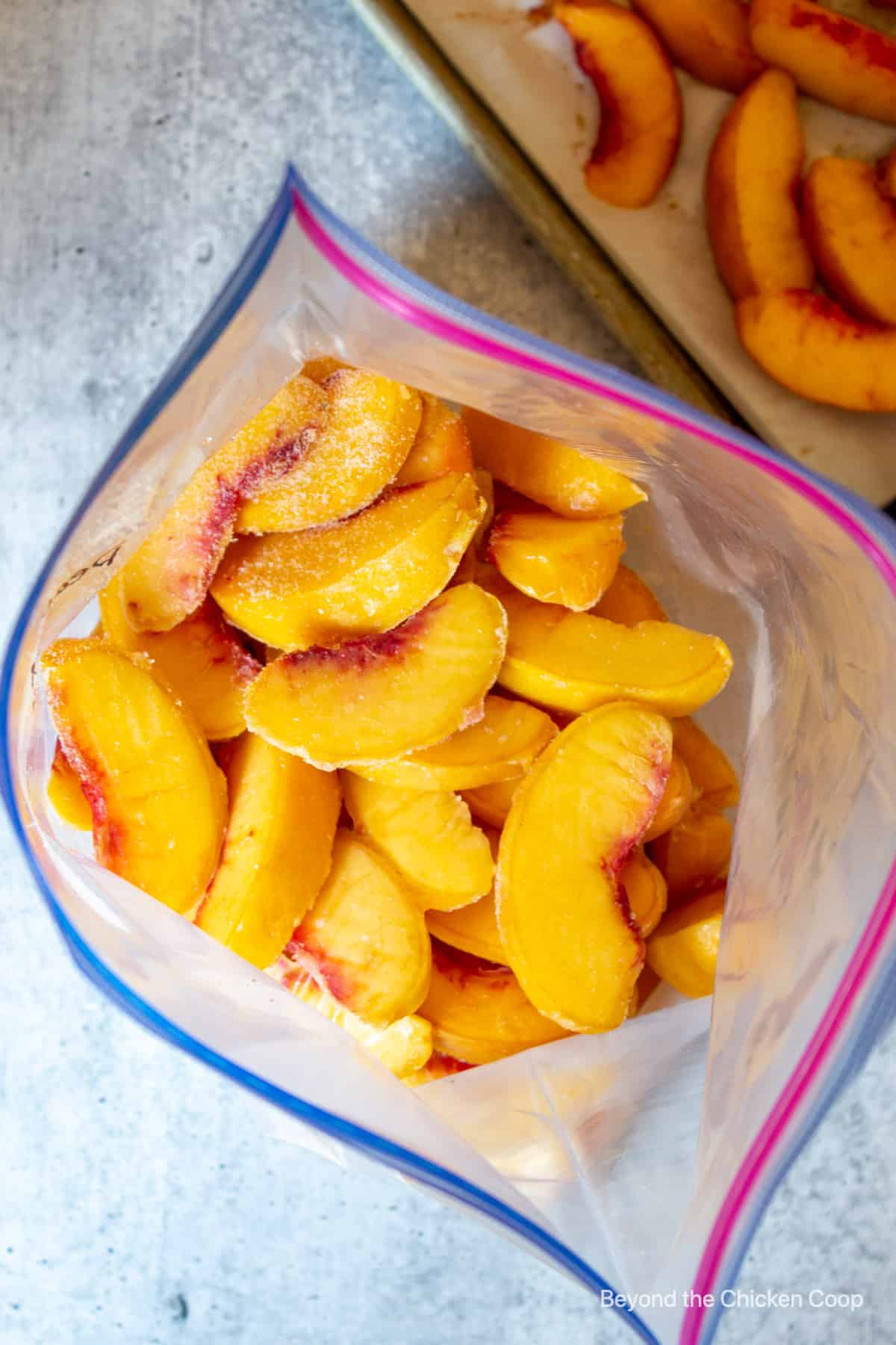 A zip top bag filled with sliced frozen peaches.