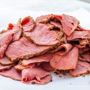 Slices of homemade pastrami on butcher paper.